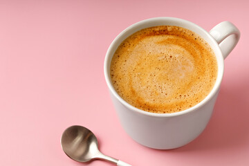 One coffee cup with Cappuccino and spoon on pink background. Espresso drink with foam. Copy space,...