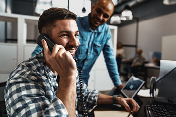 Two young men working together on a new business project in office