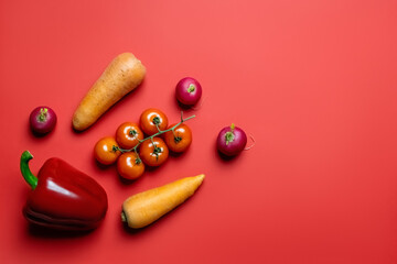 Top view of ripe vegetables on red background.