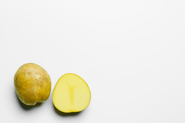 Top view of cut and whole potatoes on white background.