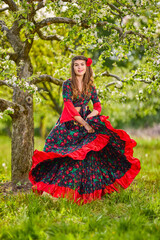 Obraz na płótnie Canvas beautiful woman in traditional gypsy dress posing in nature in spring