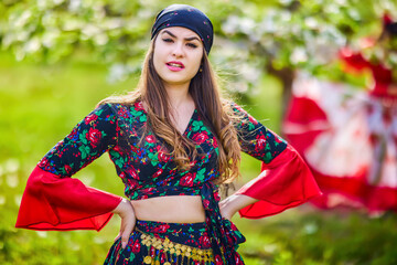 beautiful woman in traditional gypsy dress posing in nature in spring