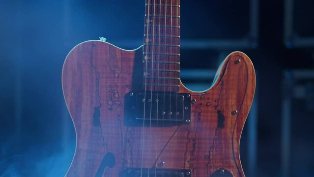 Close-up of a wooden guitar standing on the stage