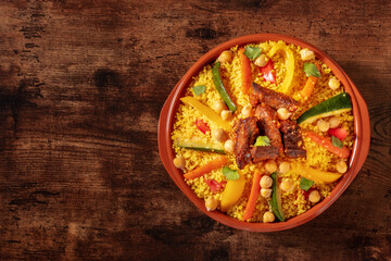 Moroccan couscous with meat, traditional festive dinner, shot from above on a wooden background with copy space