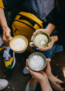 Closeup Of People Holding Different Coffee Mugs With Blue, Yellow And Green Matcha Latte.