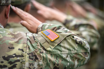 Detail shot with american flag on soldier uniform, giving the honor salute during military ceremony - 504912875