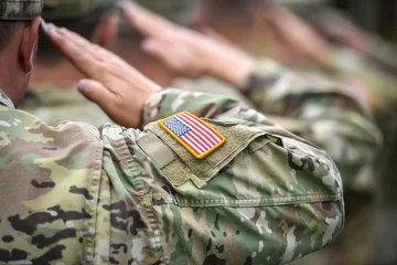 Poster Detail shot with american flag on soldier uniform, giving the honor salute during military ceremony © roibu