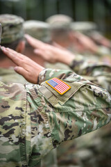 Detail shot with american flag on soldier uniform, giving the honor salute during military ceremony - 504912885