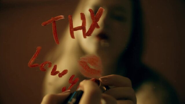 The girl writes a note on the mirror with red lipstick, thx kiss Thank you love you
