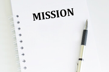 Mission text on a notebook on a table next to a pen, a business concept