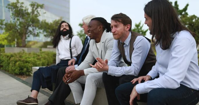 Multiracial business men sitting together outdoor during lunch break