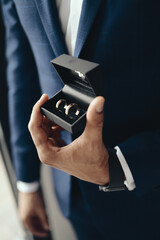 Closeup groom holding ring box