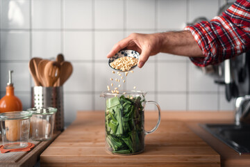 Zubereitung von Bärlauchpesto in der Küche mit Pinienkernen
