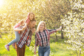 Fototapeta premium Happy family spending good time together in spring in a flowering garden