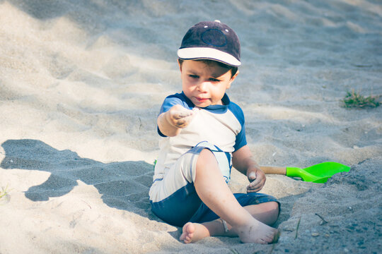 Young boy playing on the beach in sand toddler on empty beach tourism concept pre season family fun boy 2 years old having fun on the beach travel photos 