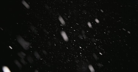 White snow falling against dark background