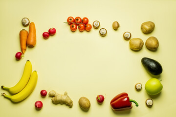 Top view of frame from whole fruits and vegetables on yellow background.