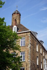 Altes Haus mit Mauerwerk in Beige und Naturfarben mit schönem alten Turm bei blauem Himmel im...