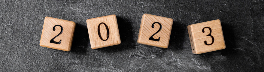 Geometric wood cubes on table with numbers 2023, Concept of new year 2023, copy space.