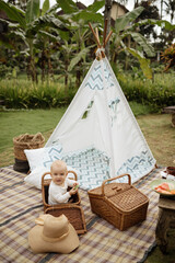 Child in front of a wigwam during a picnic. Outdoor recreation, picnic time © Yevhenii