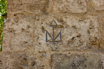 Stonemason mark carved on the ashlars of the Tenorio Tower. Archiepiscopal Palace of Alcala de Henares, Region of Madrid, Spain. - obrazy, fototapety, plakaty