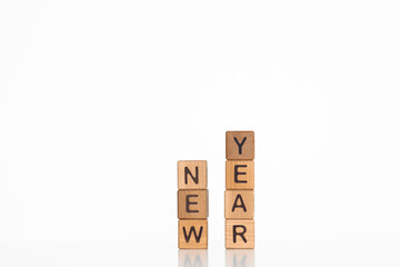 The words New Year on small wooden blocks at the desk. Conceptual photo.