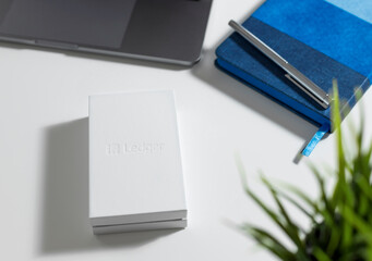 White box with Ledger hardware wallet for cryptocurrency on desktop. safe storage solution for...