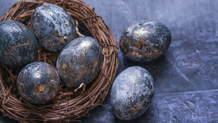 Easter card with a copy of the place for the text. Very Peri 2022 .Purple, blue eggs in a basket on a dark newspaper background. Natural dye karkade tea.