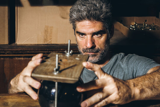 Male artisan adjusting cup in wooden press