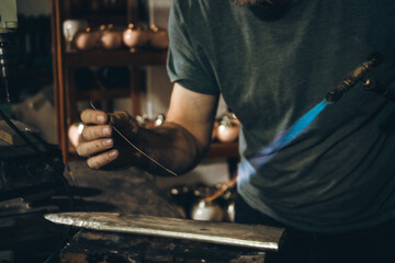 Anonymous mature silversmith using gas torch