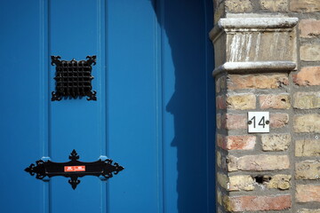 Schöne alte blaue Holztür mit altem Mauerwerk aus Backstein in Beige und Naturfarben mit...