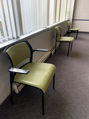 Empty doctor office waiting room chairs distanced for COVID.