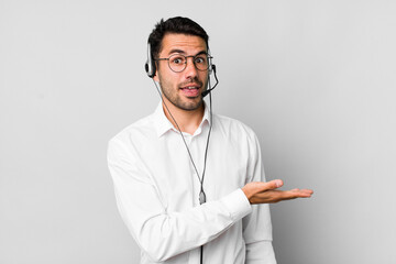 young adult hispanic man smiling cheerfully, feeling happy and showing a concept. telemarketer...