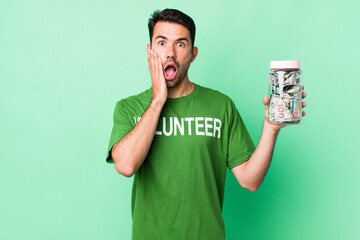 young adult hispanic man feeling shocked and scared. donation concept