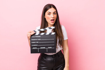 young pretty woman looking very shocked or surprised. cinema clapper concept