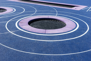 Circular trampolines sunk into the terrain. Modern new playground