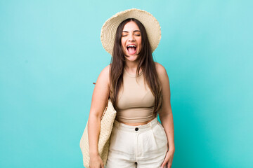 young pretty woman shouting aggressively, looking very angry. summer and hat concept