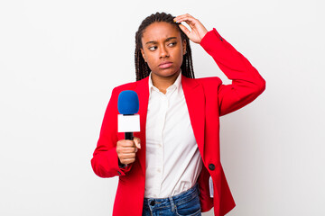 young adult black woman feeling puzzled and confused, scratching head. presenter and microphone...