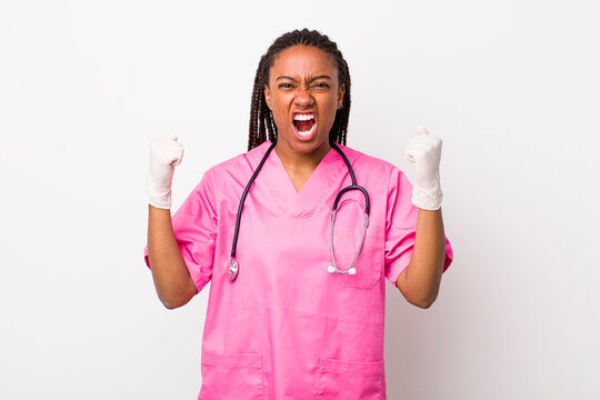 young adult black woman shouting aggressively with an angry expression. veterinarian concept