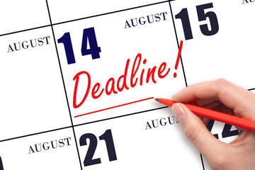 14th day of August. Hand drawing red line and writing the text Deadline on calendar date August 14....
