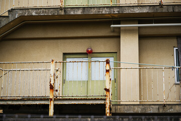 錆びた外階段と赤いランプの付いた建物