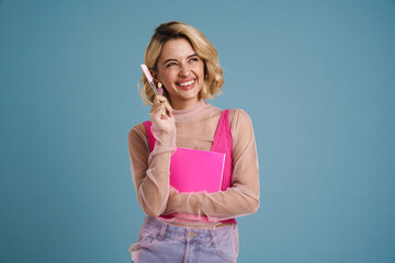 Young blonde woman smiling while posing exercise book
