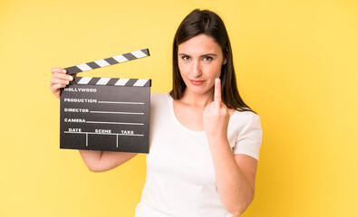 young adult pretty woman feeling angry, annoyed, rebellious and aggressive. cinema clapper concept