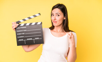 young adult pretty woman looking arrogant, successful, positive and proud. cinema clapper concept