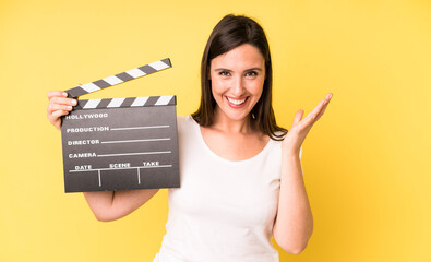 young adult pretty woman feeling happy, surprised realizing a solution or idea. cinema clapper...