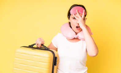 young adult pretty woman looking shocked, scared or terrified, covering face with hand. flight...