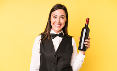 young adult pretty woman looking happy and pleasantly surprised. waiter and wine bottle concept
