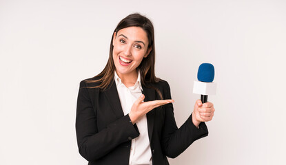 young adult pretty woman smiling cheerfully, feeling happy and showing a concept. presenter with a...