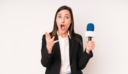 young adult pretty woman feeling extremely shocked and surprised. presenter with a microphone...