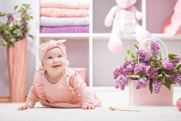 baby with lilac flowers at home or kindergarten